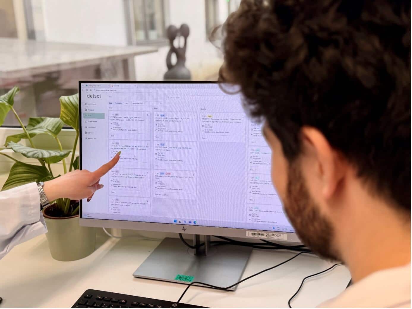 Zwei Mitarbeitende besprechen DELARIS Projektdaten am Monitor zur Entwicklung nachhaltiger Verpackungslösungen