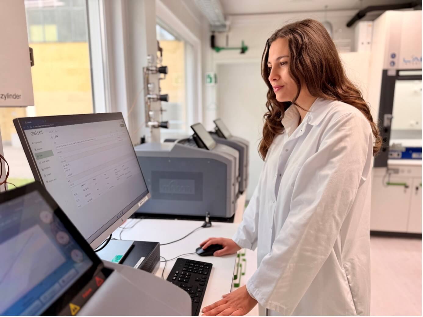 Mitarbeiterin im Labor arbeitet mit DELARIS Software zur Entwicklung nachhaltiger Verpackungen und Barrierepapiere